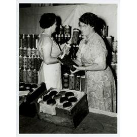 Two Women Unpacking Preserves for District Exhibit Display, 1955